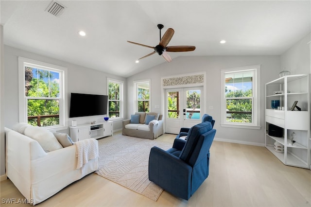 living area featuring lofted ceiling, ceiling fan, wood finished floors, and a healthy amount of sunlight