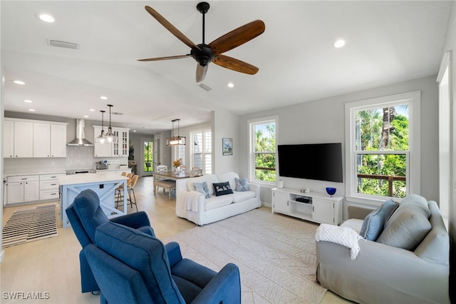 living room with visible vents, lofted ceiling, ceiling fan, and recessed lighting