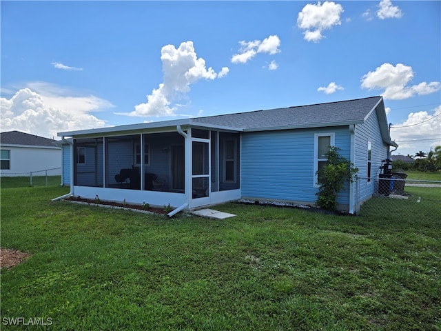 rear view of property featuring a yard and a sunroom