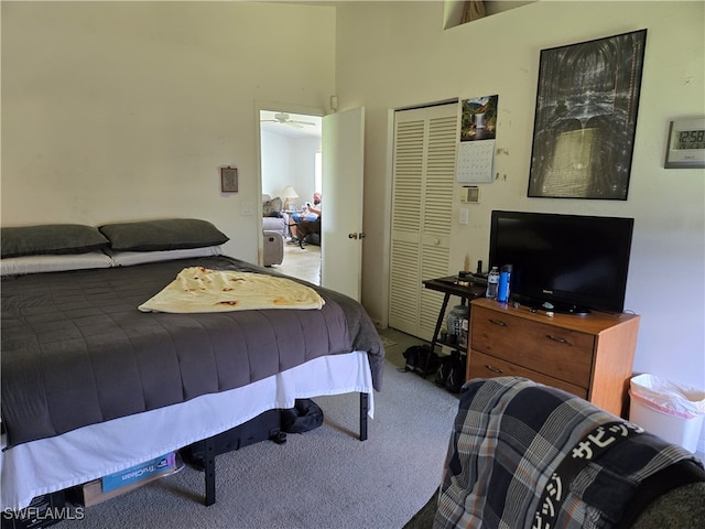 carpeted bedroom with a high ceiling and a closet