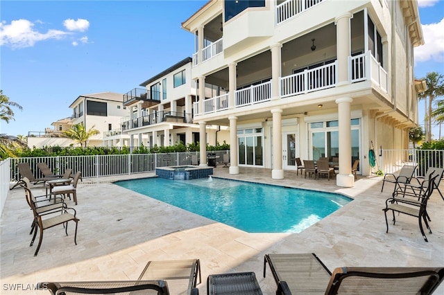 view of pool featuring a pool with connected hot tub, fence, and a patio