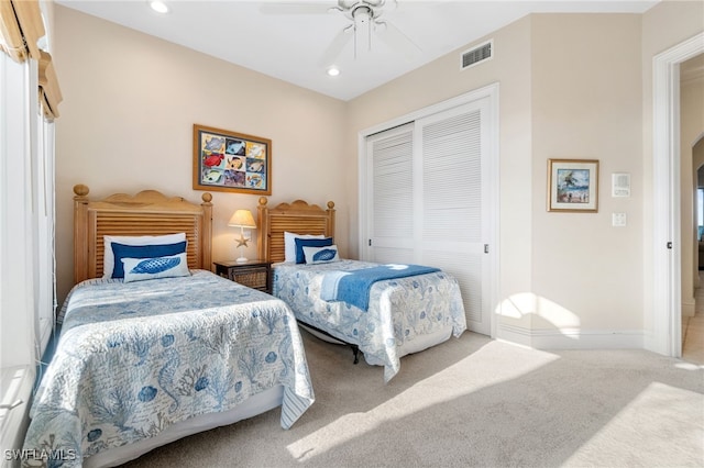 carpeted bedroom featuring a closet and ceiling fan