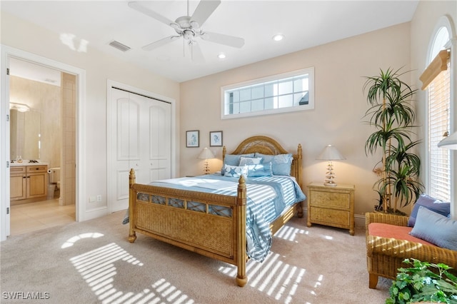 bedroom with recessed lighting, a closet, visible vents, light carpet, and ensuite bath