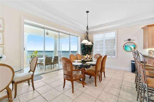 dining room featuring light tile patterned floors, ornamental molding, a water view, and baseboards