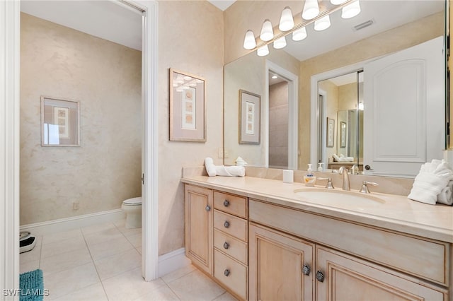 bathroom with baseboards, visible vents, toilet, tile patterned floors, and vanity