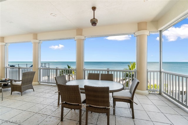 view of patio featuring a water view, a balcony, and a view of the beach