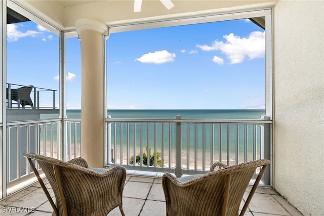 balcony featuring a view of the beach and a water view