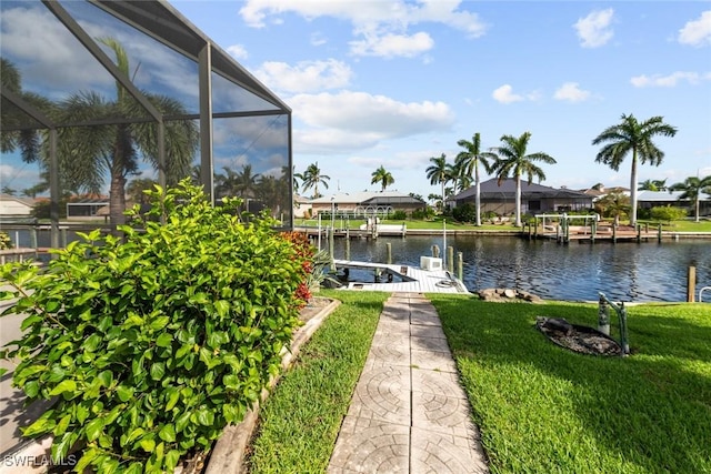 view of dock featuring a water view, a lanai, and a yard