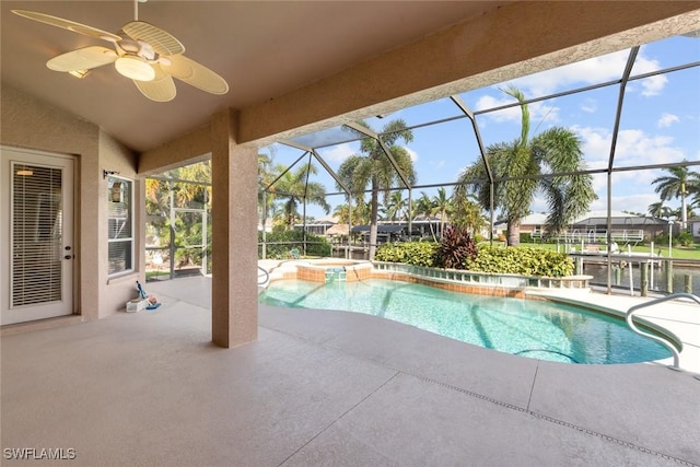 view of pool featuring a patio area, a water view, a lanai, an in ground hot tub, and ceiling fan