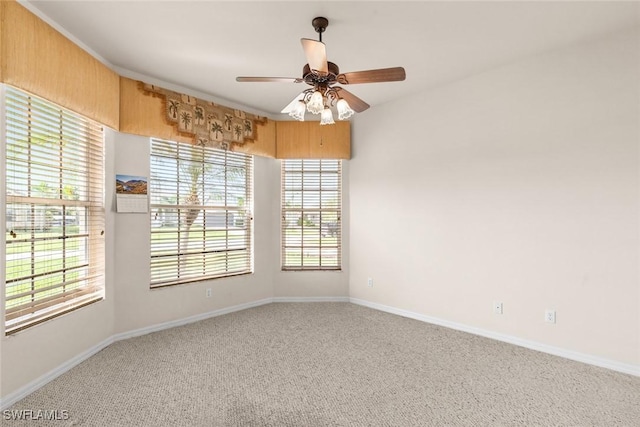 carpeted empty room with a wealth of natural light and ceiling fan