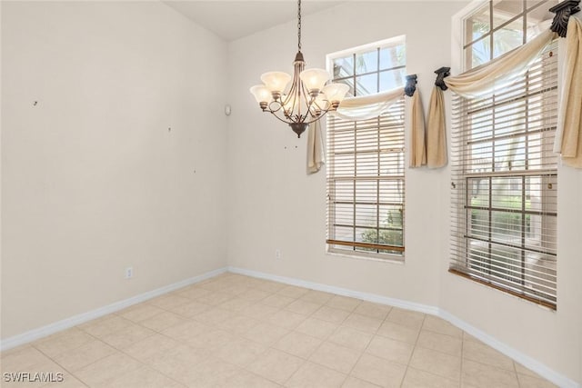 spare room featuring an inviting chandelier and plenty of natural light