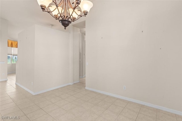 unfurnished room with light tile patterned flooring and a chandelier