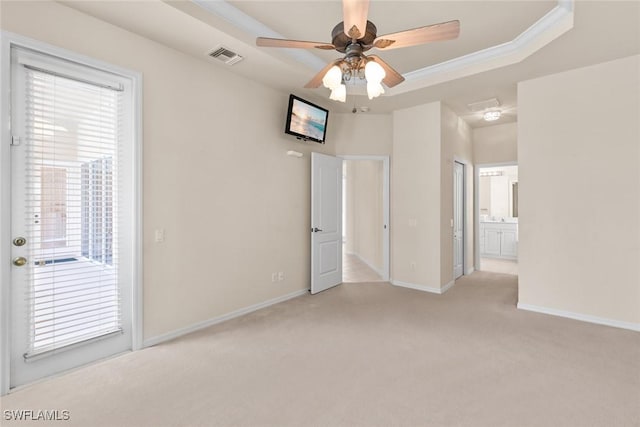 carpeted spare room featuring ornamental molding, ceiling fan, and a tray ceiling