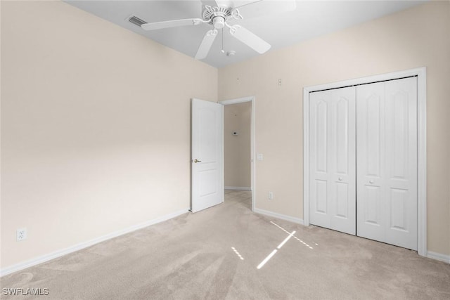 unfurnished bedroom featuring light colored carpet, a closet, and ceiling fan