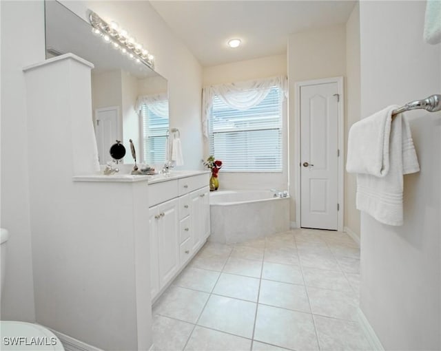 bathroom with vanity, a relaxing tiled tub, tile patterned floors, and toilet