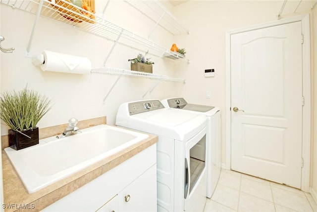 washroom with cabinets, independent washer and dryer, sink, and light tile patterned floors