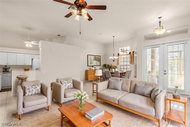 tiled living room featuring ceiling fan and french doors