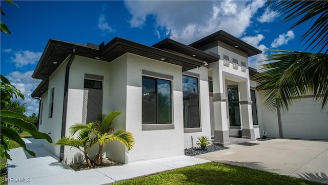 view of side of property with a garage and stucco siding