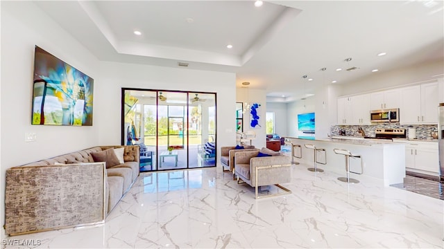 tiled living room featuring a tray ceiling