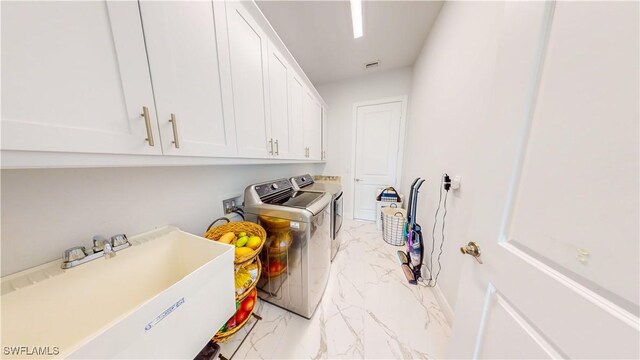 washroom with washing machine and clothes dryer, cabinets, sink, and light tile patterned flooring