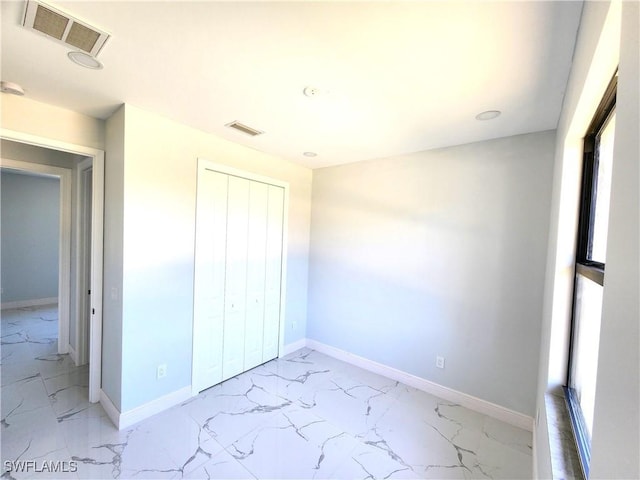 unfurnished bedroom featuring marble finish floor, multiple windows, visible vents, and baseboards