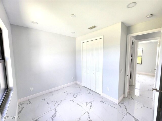 unfurnished bedroom featuring light tile patterned floors and a closet