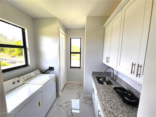 laundry area featuring a sink, baseboards, marble finish floor, independent washer and dryer, and cabinet space