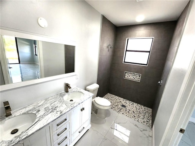 full bathroom with a tile shower, marble finish floor, and a sink