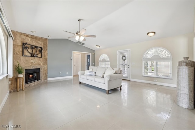 tiled living room with lofted ceiling, a fireplace, and ceiling fan