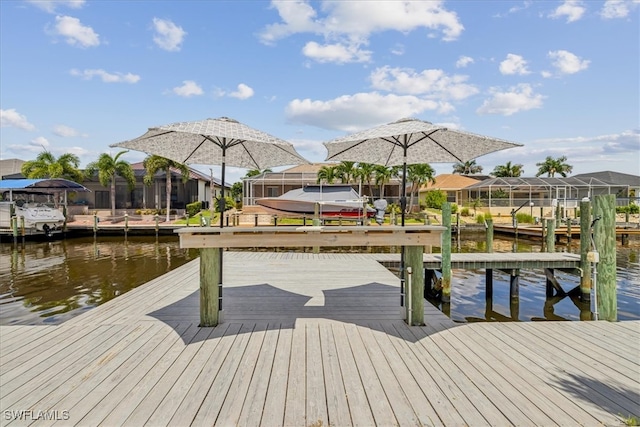 view of dock with a lanai and a water view