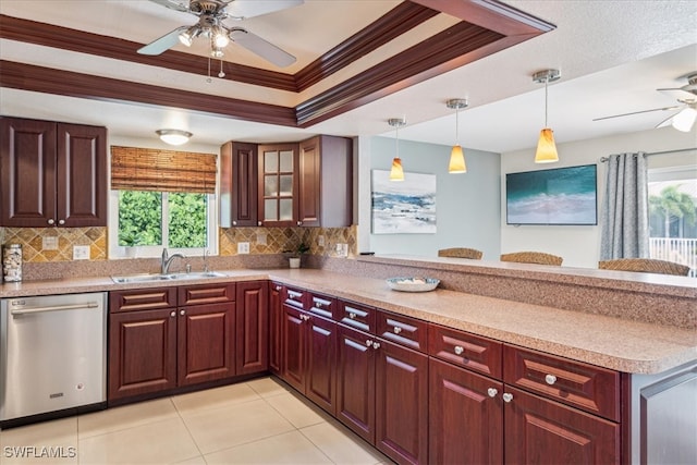 kitchen featuring sink, dishwasher, a raised ceiling, and tasteful backsplash