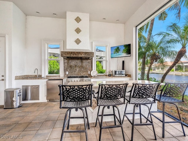 view of patio with exterior kitchen and a wet bar