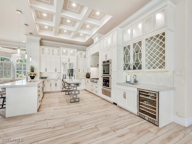 kitchen featuring pendant lighting, coffered ceiling, beamed ceiling, a kitchen bar, and beverage cooler