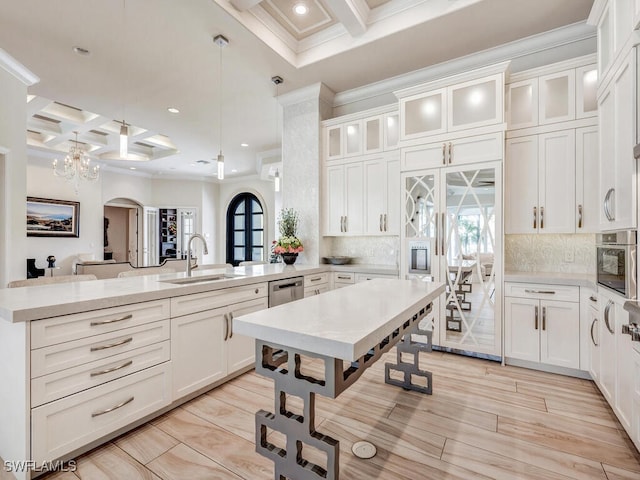 kitchen with backsplash, built in refrigerator, pendant lighting, and coffered ceiling