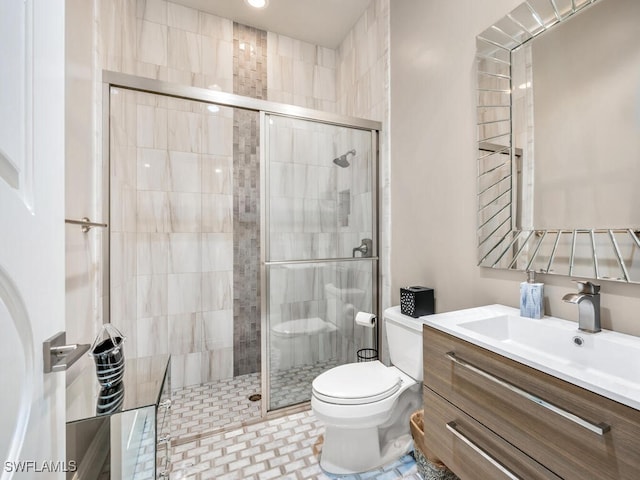 bathroom featuring vanity, toilet, and a shower with shower door