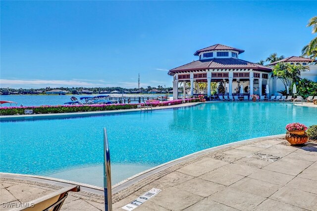 view of swimming pool with a gazebo and a water view