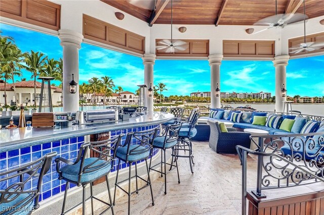 view of patio / terrace with ceiling fan, a bar, and an outdoor living space