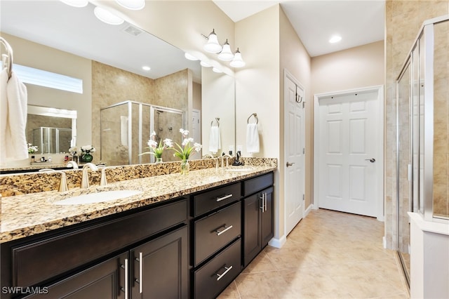 bathroom with tile patterned floors, walk in shower, and vanity