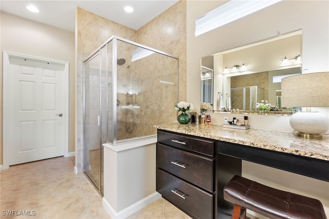 bathroom featuring vanity, tile patterned flooring, and a shower with door