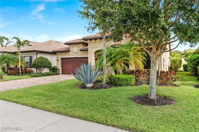 mediterranean / spanish house featuring a garage and a front yard