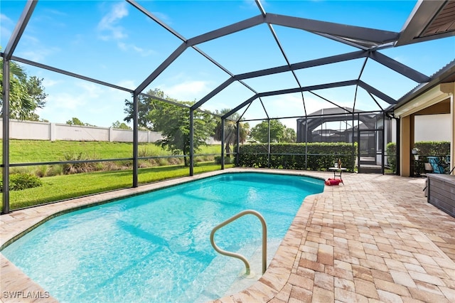 view of swimming pool featuring a lanai, a yard, and a patio