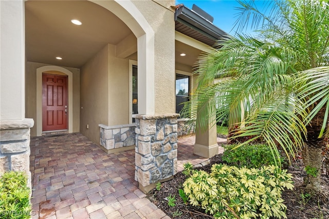 property entrance featuring stone siding and stucco siding