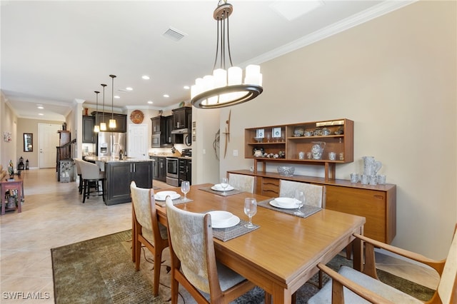 tiled dining area featuring ornamental molding and sink