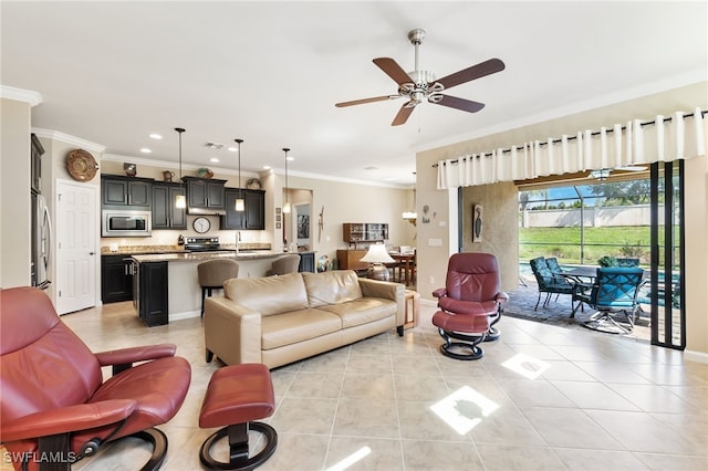 living room featuring ceiling fan, ornamental molding, light tile patterned floors, and sink