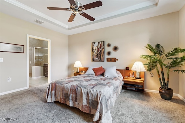 carpeted bedroom with a raised ceiling, ensuite bathroom, and ceiling fan