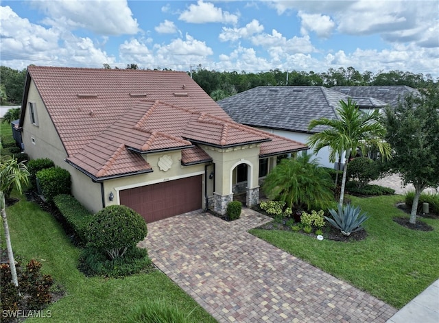 mediterranean / spanish house featuring a garage, a front yard, and a tile roof