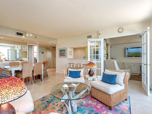 living room featuring light tile patterned floors and french doors