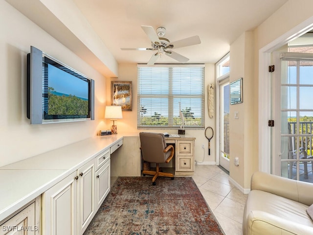 office space with light tile patterned floors, built in desk, and ceiling fan