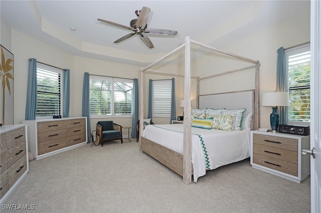 carpeted bedroom with ceiling fan and multiple windows