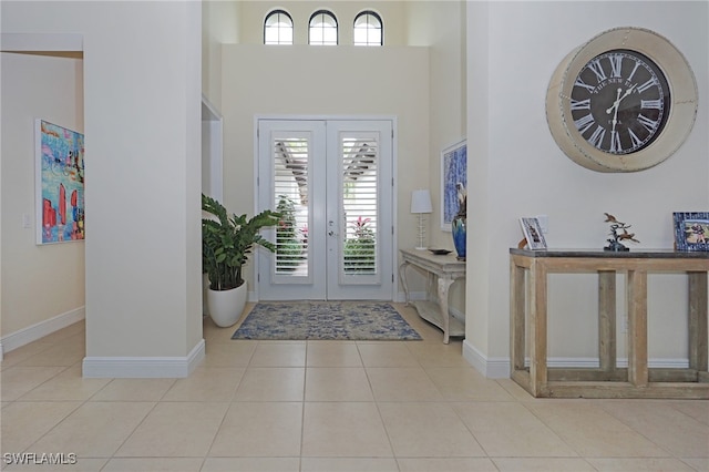 entrance foyer with french doors, light tile patterned floors, and a high ceiling